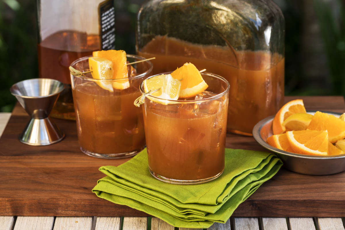 Two Glasses Of Bourbon Iced Tea Punch Topped With Orange Wedges