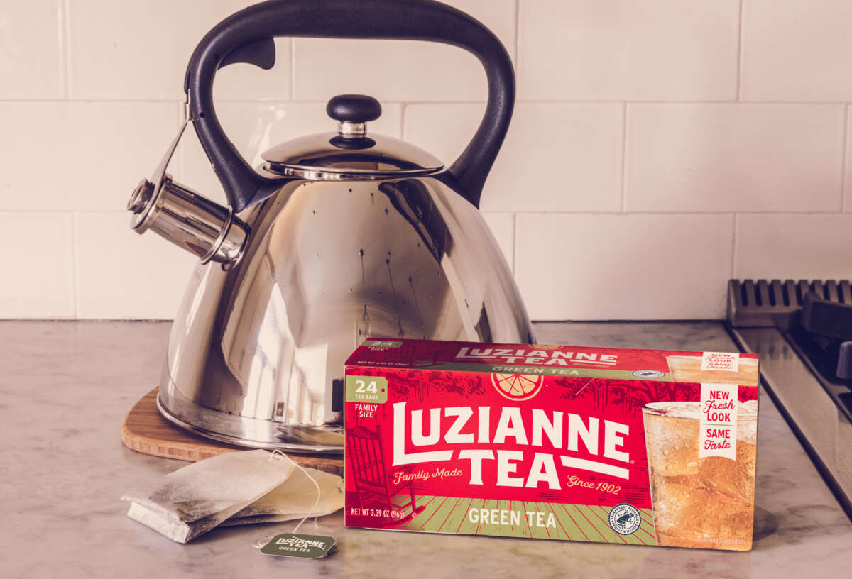 Box of green tea in front of a kettle