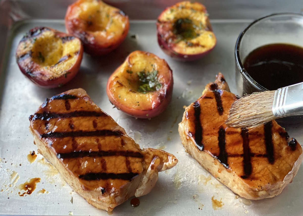 Sweet Tea Brined and Glazed Pork Chops with grilled peaches on a serving tray