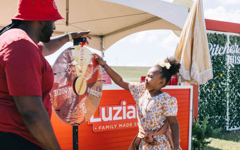 a little girl spinning the Luzianne wheel to win swag at a festival